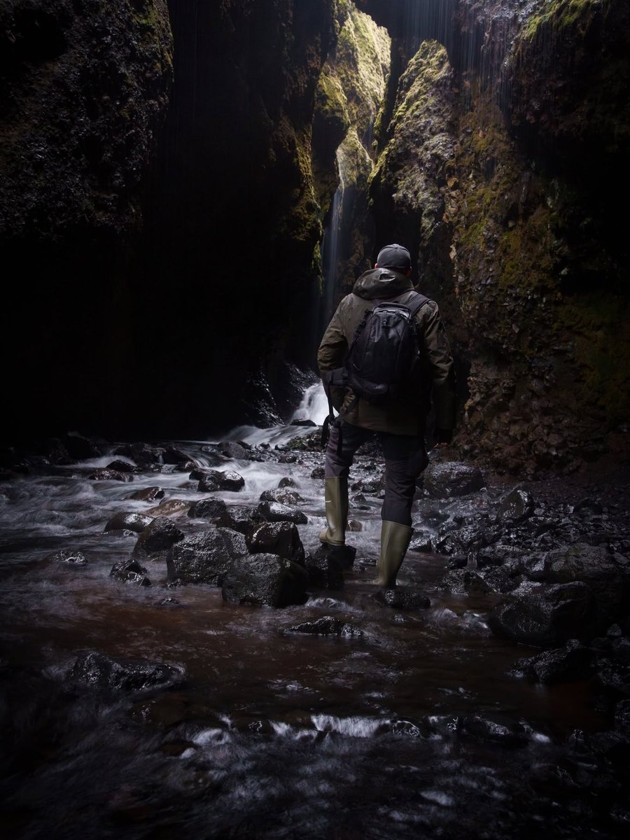 Outdoor waterfall photography scene with mist and camera gear